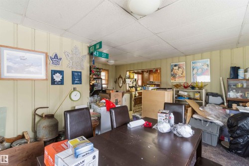 This room features light-colored paneled walls and a drop ceiling with a central light fixture - 10186 143 Street, Edmonton, AB - Indoor