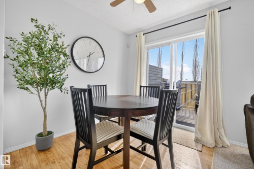 Dining area featuring hardwood floors, a ceiling fan, and a glass sliding door leading to an outdoor space - 9051 Scott Crescent, Edmonton, AB - Indoor Photo Showing Dining Room