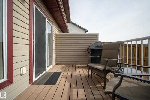 The property features a spacious outdoor deck with wood-look decking, a sliding glass door for access, and a white railing - 9051 Scott Crescent, Edmonton, AB - Outdoor With Deck Patio Veranda With Exterior