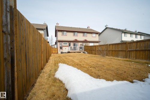 The property features a fenced backyard with a lawn area and a wooden deck - 9051 Scott Crescent, Edmonton, AB - Outdoor With Deck Patio Veranda
