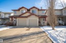 Exterior view of the property featuring a two-car garage, a concrete driveway, and a front entrance with a porch - 9051 Scott Crescent, Edmonton, AB  - Outdoor With Facade 