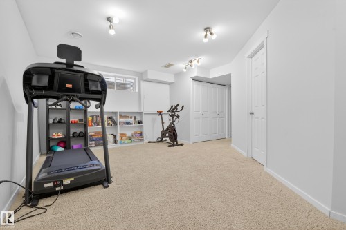 Spacious room with light-colored carpeting, multiple light fixtures, and white walls - 9051 Scott Crescent, Edmonton, AB - Indoor Photo Showing Gym Room