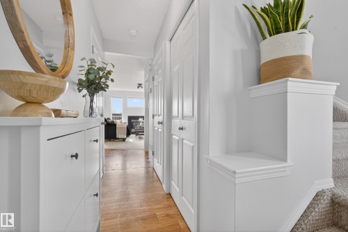 Welcoming hallway featuring hardwood flooring, white paneled doors, and a staircase with carpeted treads - 9051 Scott Crescent, Edmonton, AB - Indoor Photo Showing Other Room