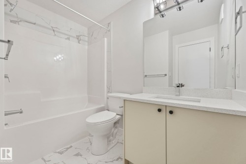 Bathroom featuring a white bathtub with a shower, a toilet, and a vanity with a white countertop and rectangular sink - 14 Dalquist Bay, Leduc, AB - Indoor Photo Showing Bathroom