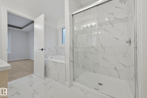 Bathroom featuring a glass-enclosed shower with white marble-patterned tile, a built-in bathtub, and matching marble-patterned floor tiles - 14 Dalquist Bay, Leduc, AB - Indoor Photo Showing Bathroom