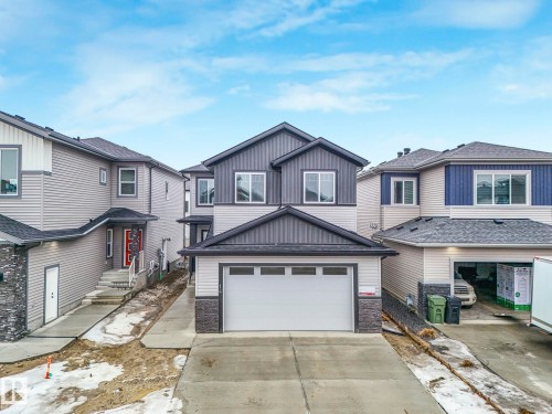 The property features a two-story design with a gray and light-colored siding exterior, complemented by dark gray roofing - 14 Dalquist Bay, Leduc, AB - Outdoor With Facade