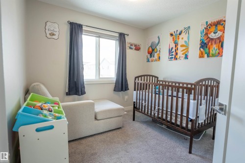 This room features a window with dark curtains, light-colored walls, and carpeting - 656 Black Stone, Leduc, AB - Indoor Photo Showing Bedroom