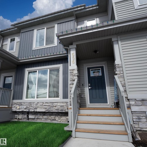 The property features a charming exterior with a dark blue entry door, grey siding, and stone accents - 656 Black Stone, Leduc, AB - Outdoor