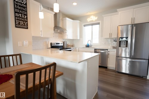 Modern kitchen featuring white cabinetry, light countertops, stainless steel appliances, and a white subway tile backsplash - 656 Black Stone, Leduc, AB - Indoor Photo Showing Kitchen With Stainless Steel Kitchen With Upgraded Kitchen