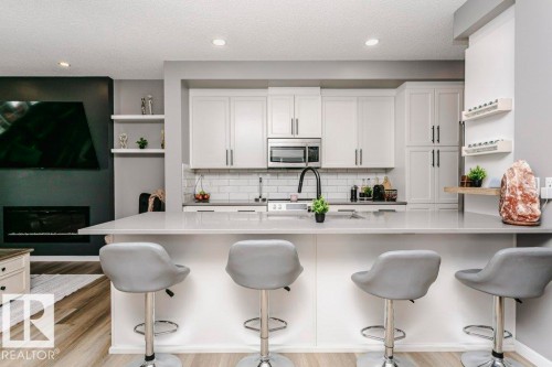 Well-appointed kitchen featuring light-colored cabinetry, a subway tile backsplash, and stainless steel appliances - 320 Balsam Link, Leduc, AB - Indoor Photo Showing Kitchen With Upgraded Kitchen