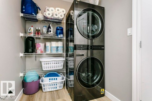 Laundry area featuring a stacked washer and dryer, and wire shelving for storage - 320 Balsam Link, Leduc, AB - Indoor Photo Showing Laundry Room