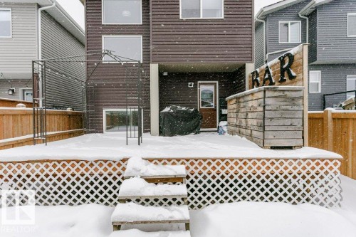 The property features a wood deck with lattice skirting and stairs leading to the yard - 320 Balsam Link, Leduc, AB - Outdoor With Exterior
