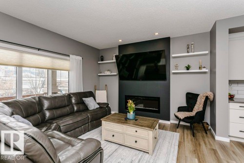 The living area features a large window with blinds, a fireplace, and recessed lighting - 320 Balsam Link, Leduc, AB - Indoor Photo Showing Living Room With Fireplace