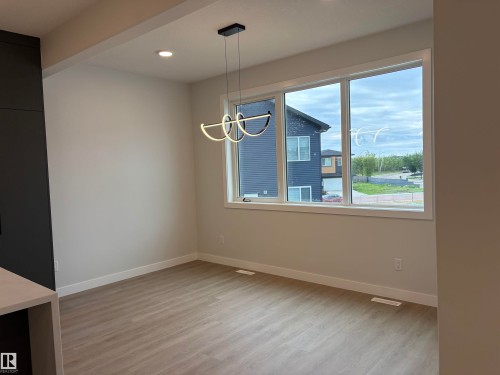 Bright dining area featuring a modern pendant light fixture and recessed ceiling lighting - 1039 151 Ave, Edmonton, AB 