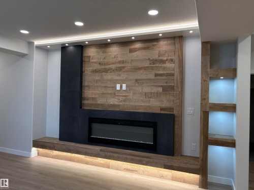 Feature wall with wood-finish paneling and integrated electric fireplace - 1039 151 Ave, Edmonton, AB 