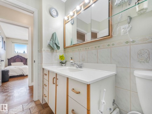 Bathroom featuring a vanity with a white countertop and a mirror with integrated lighting - 16106 79A Avenue Nw, Edmonton, AB - Indoor Photo Showing Bathroom