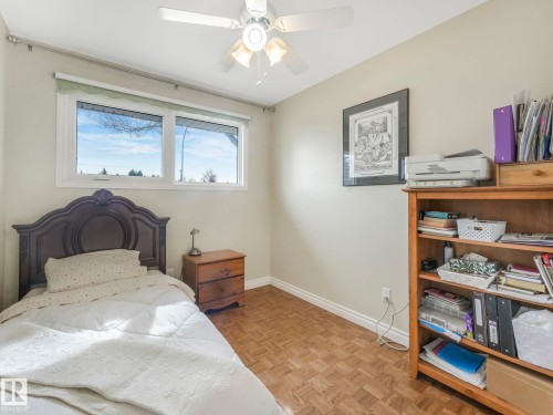 This room features parquet flooring, a ceiling fan, and a window providing natural light - 16106 79A Avenue Nw, Edmonton, AB - Indoor Photo Showing Bedroom