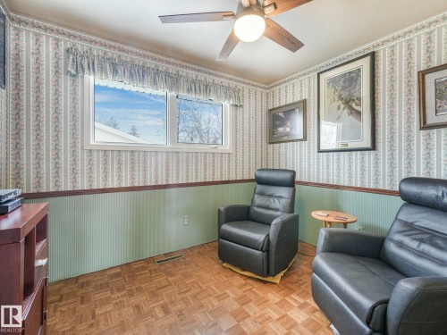 This room features a window providing natural light, a ceiling fan with integrated lighting, and parquet flooring - 16106 79A Avenue Nw, Edmonton, AB - Indoor Photo Showing Other Room