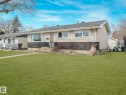 The property features a well-maintained front lawn and a stone façade accent - 16106 79A Avenue Nw, Edmonton, AB  - Outdoor 