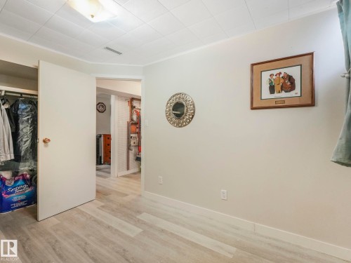 This room features light-colored walls, a closet with an open door, and light-toned plank flooring - 16106 79A Avenue Nw, Edmonton, AB - Indoor Photo Showing Other Room