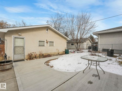 The property features an exterior with light-colored stucco siding, a white entry door, and two windows - 16106 79A Avenue Nw, Edmonton, AB - Outdoor With Exterior