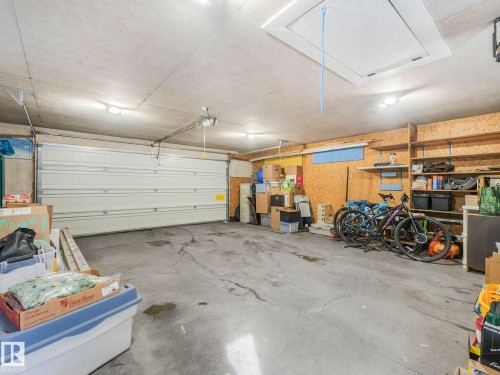 The property features a garage with a roll-up door, exposed ceiling, and integrated lighting - 16106 79A Avenue Nw, Edmonton, AB - Indoor Photo Showing Garage
