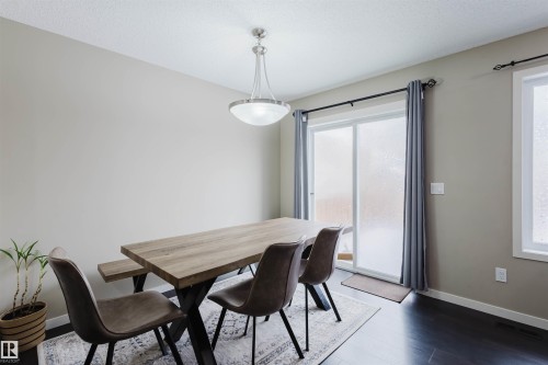 Dining area featuring dark wood flooring, a ceiling-mounted light fixture, and a sliding glass door - 16811 120 Street, Edmonton, AB - Indoor Photo Showing Dining Room