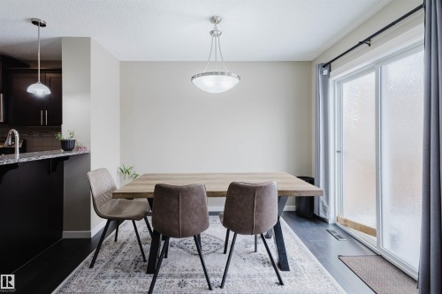 This dining area features dark flooring, light-toned walls, and a ceiling light fixture - 16811 120 Street, Edmonton, AB - Indoor Photo Showing Dining Room