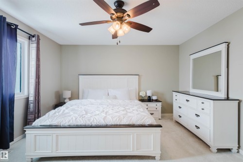 The bedroom features neutral-toned walls, a window with curtains, and an overhead ceiling fan with lighting - 16811 120 Street, Edmonton, AB - Indoor Photo Showing Bedroom