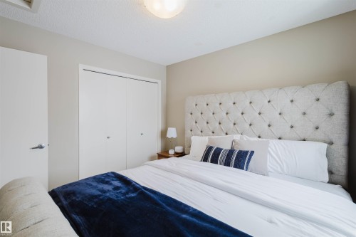 This room features a neutral color palette, a ceiling light fixture, and closet doors with silver-toned handles - 16811 120 Street, Edmonton, AB - Indoor Photo Showing Bedroom