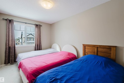 Bedroom featuring light-colored walls, a window with dark curtains, and light-colored carpeting - 16811 120 Street, Edmonton, AB - Indoor Photo Showing Bedroom