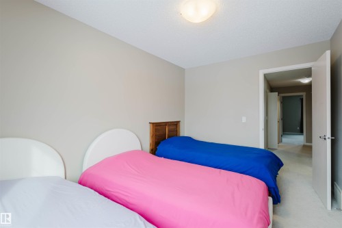 A well-lit room featuring neutral-toned walls, carpeted flooring, and a ceiling-mounted light fixture - 16811 120 Street, Edmonton, AB - Indoor Photo Showing Bedroom