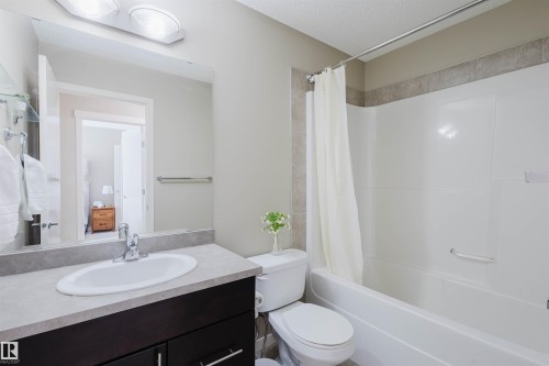This bathroom features a vanity with a white sink, a mirror, and a toilet - 16811 120 Street, Edmonton, AB - Indoor Photo Showing Bathroom