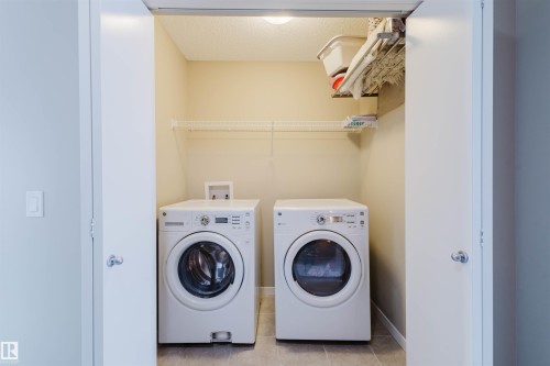 Dedicated laundry area with a washer and dryer, featuring overhead wire shelving for convenience - 16811 120 Street, Edmonton, AB - Indoor Photo Showing Laundry Room
