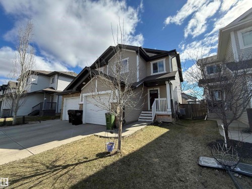 The property features a two-story exterior with a combination of beige siding and stone accents - 16811 120 Street, Edmonton, AB - Outdoor With Facade