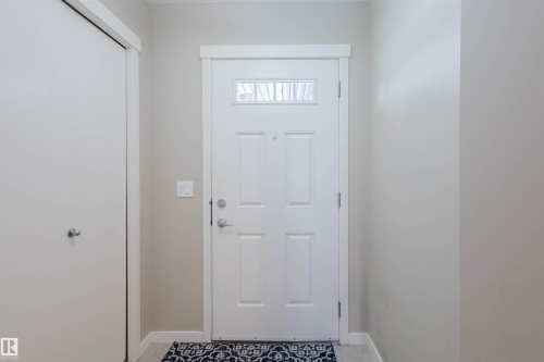 Welcoming entryway featuring a paneled door with an upper window, light-colored walls, and a convenient closet - 16811 120 Street, Edmonton, AB - Indoor Photo Showing Other Room