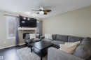 Living area featuring dark hardwood floors, a fireplace with a mantel, and a ceiling fan with integrated lighting - 16811 120 Street, Edmonton, AB  - Indoor Photo Showing Living Room With Fireplace 