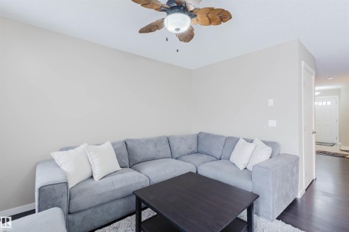 Living area featuring a ceiling fan with light fixture, light-colored walls, and dark flooring - 16811 120 Street, Edmonton, AB - Indoor Photo Showing Living Room
