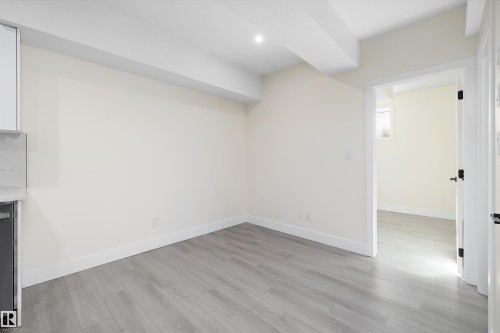 This room features light-colored walls, recessed lighting, and light grey flooring - 8319 81Ave, Edmonton, AB - Indoor Photo Showing Other Room