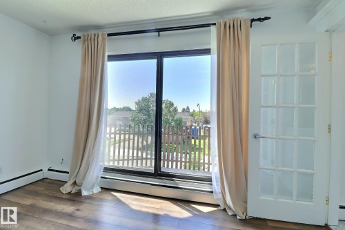 Unfurnished room featuring wood-type flooring - 304 11907 81 Street, Edmonton, AB - Indoor Photo Showing Other Room