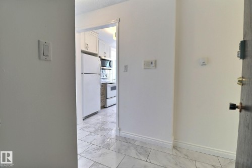 Hallway with baseboards and light marble finish floors - 304 11907 81 Street, Edmonton, AB - Indoor