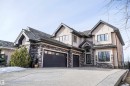 The property features a multi-story exterior with light-colored stucco and dark stone accents - 4016 Mactaggart Drive, Edmonton, AB  - Outdoor With Facade 