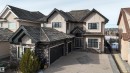 The property features a stucco exterior with stone accents, a multi-car garage, and a textured roof - 4016 Mactaggart Drive, Edmonton, AB  - Outdoor With Facade 