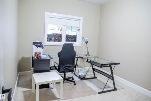 This room features a window providing natural light, neutral wall paint, and carpeted flooring - 4016 Mactaggart Drive, Edmonton, AB - Indoor Photo Showing Office