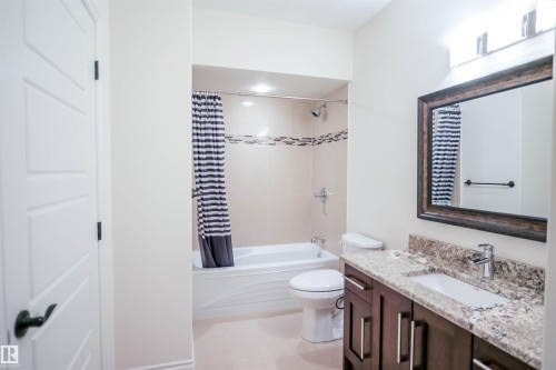 Bathroom featuring a vanity with a granite countertop and an under-mount sink - 4016 Mactaggart Drive, Edmonton, AB - Indoor Photo Showing Bathroom