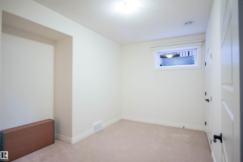The room features neutral-toned walls, a light-colored carpet, and a window with white trim, offering natural light - 4016 Mactaggart Drive, Edmonton, AB - Indoor Photo Showing Other Room