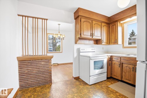 Kitchen featuring wood cabinetry, a white electric range, and a window providing natural light - 6503 106A Avenue, Edmonton, AB - Indoor Photo Showing Kitchen