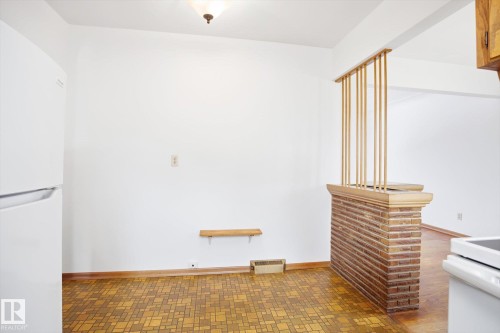 This area features a white refrigerator, light-colored walls, and a patterned floor - 6503 106A Avenue, Edmonton, AB - Indoor Photo Showing Other Room