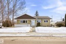 The property features a ranch-style exterior with a brown roof and light-colored siding, set on a lot with mature trees and a front yard - 6503 106A Avenue, Edmonton, AB  - Outdoor 