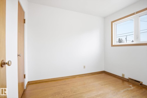 The property features light wood flooring and a window with wood trim - 6503 106A Avenue, Edmonton, AB - Indoor Photo Showing Other Room